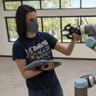 Sarah O’Meara, the chief scientist in Professor Robinson’s Lab, working with a supernumerary robotic arm. (Steve Robinson/UC Davis)